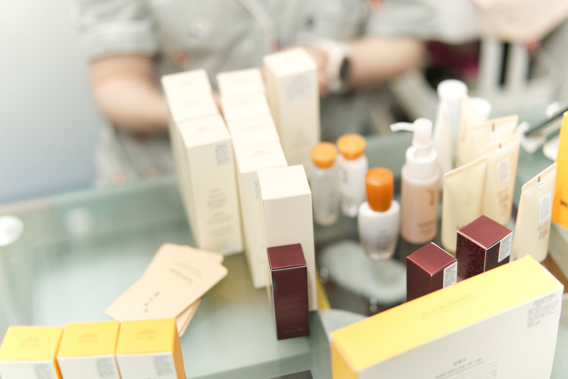 cosmetic products on table with woman